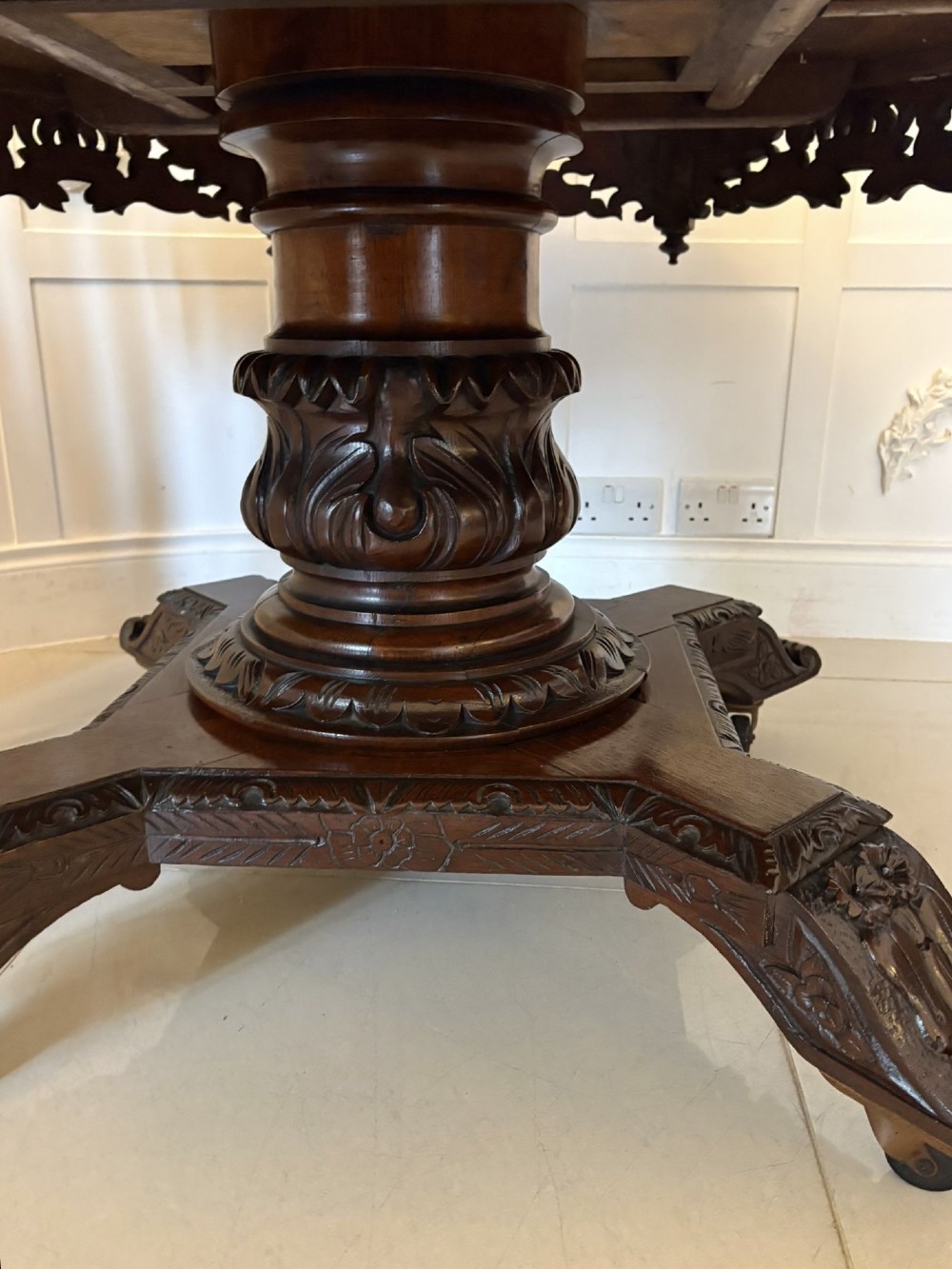 An antique Victorian octagonal dark oak centre table featuring heavily carved foliate designs along the apron and a sturdy central base. View XI