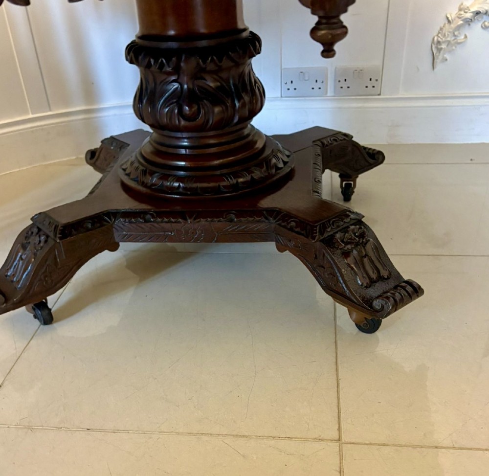 An antique Victorian octagonal dark oak centre table featuring heavily carved foliate designs along the apron and a sturdy central base. View XIII