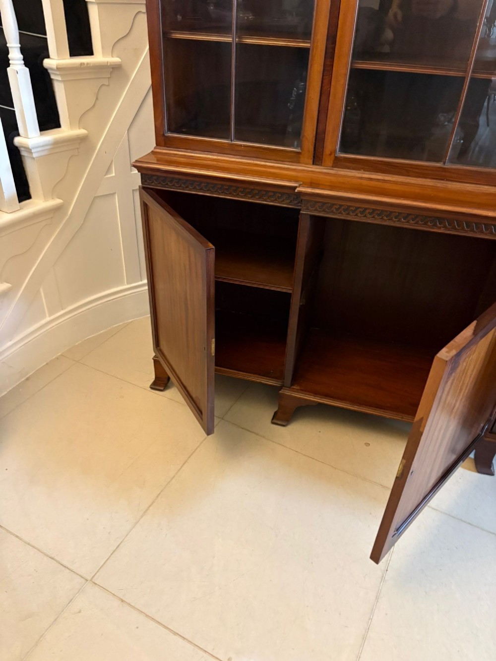 An antique Edwardian mahogany breakfront bookcase featuring three glazed upper doors with astragal moulding above three solid wooden cabinet doors. View VI