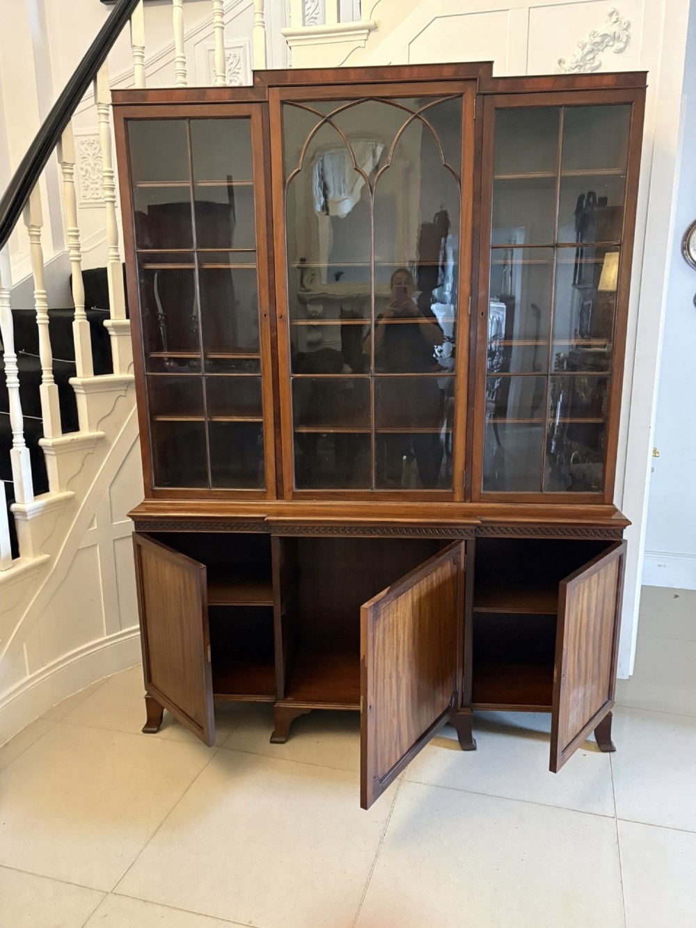 An antique Edwardian mahogany breakfront bookcase featuring three glazed upper doors with astragal moulding above three solid wooden cabinet doors. View VIII