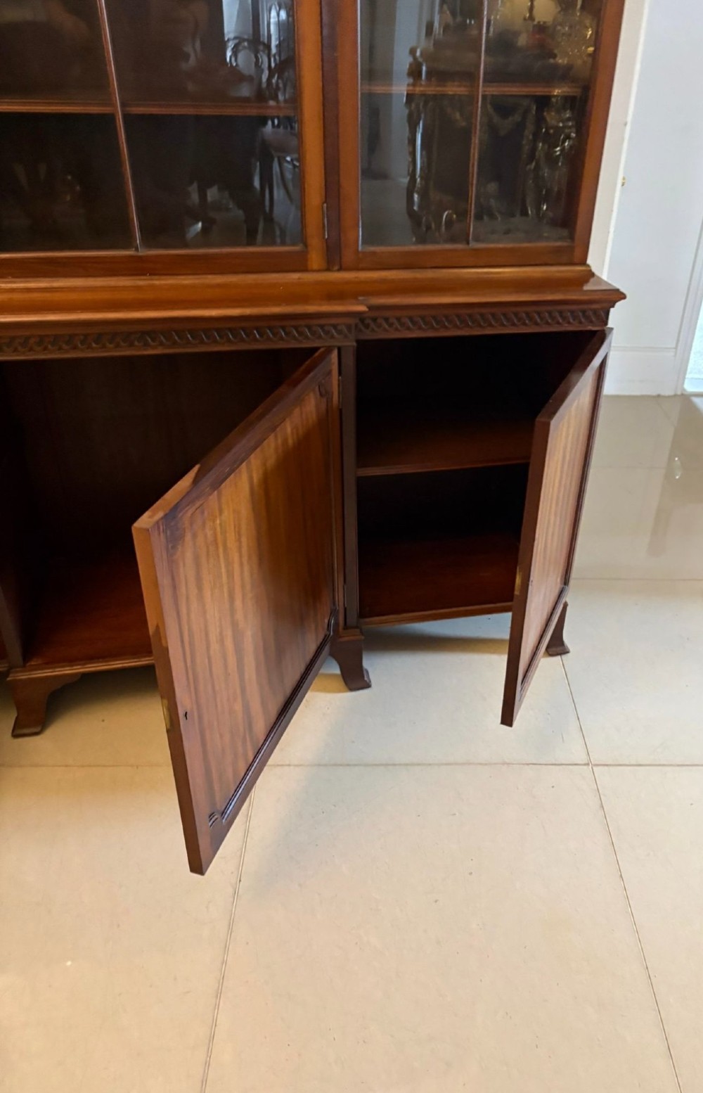 An antique Edwardian mahogany breakfront bookcase featuring three glazed upper doors with astragal moulding above three solid wooden cabinet doors. View IX