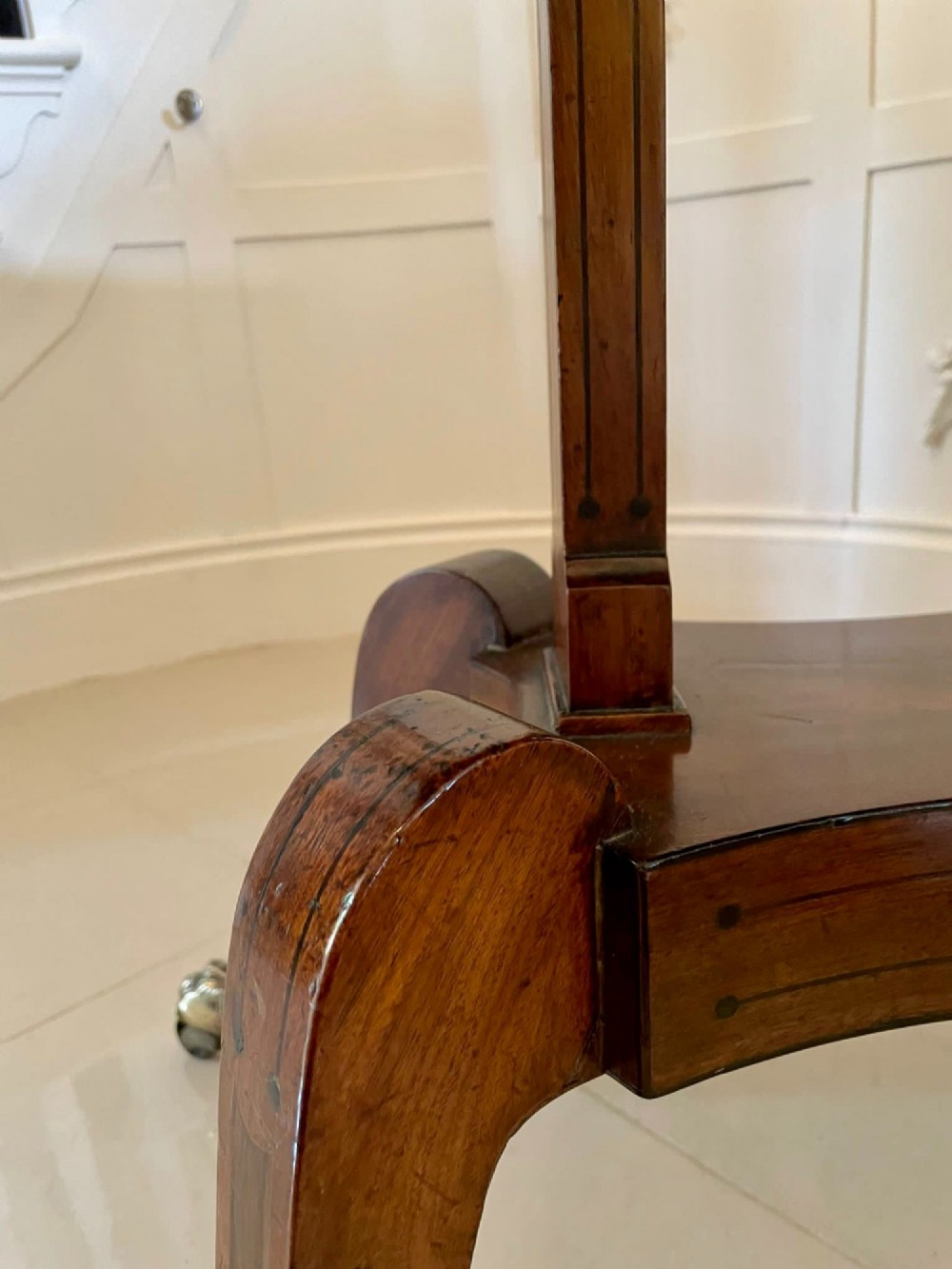 A Regency mahogany fold-over card table featuring an inlaid apron, central pedestal support, and four sabre legs with brass lion paw feet and castors. View VI