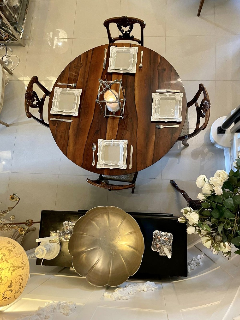 A circular William IV rosewood dining table shown with its top tilted vertically to display the rich wood grain and supported on a carved base with paw feet. View IX