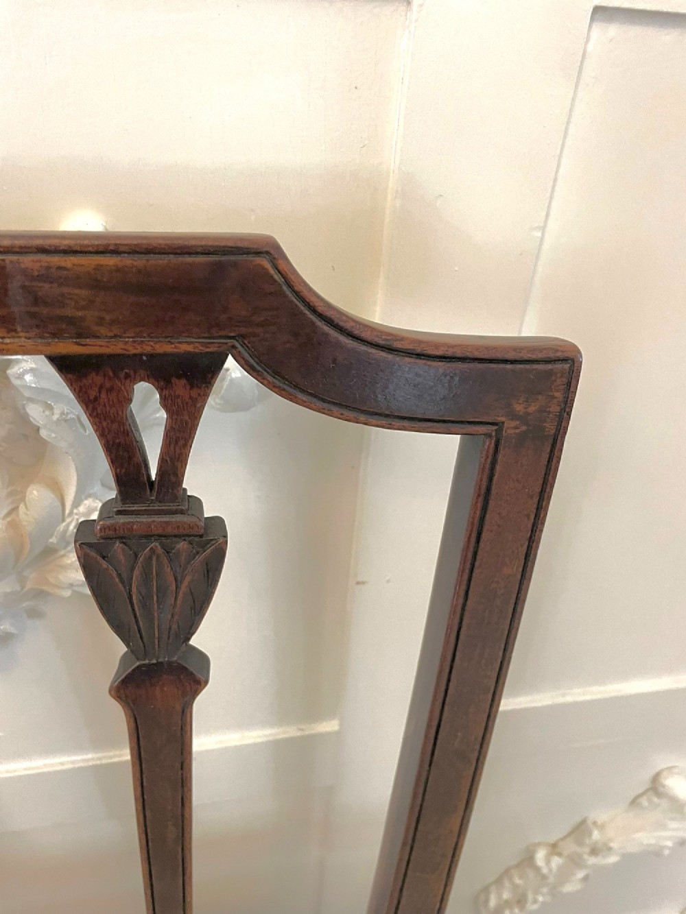 A set of eight George III mahogany dining chairs featuring carved vertical back splats and beige plaid upholstered drop-in seats, including six side chairs and two armchairs. View IV