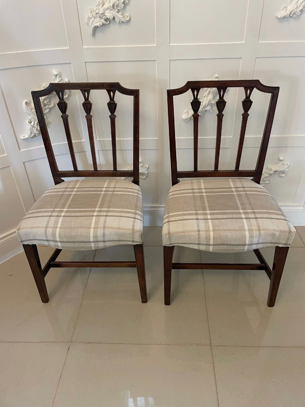 A set of eight George III mahogany dining chairs featuring carved vertical back splats and beige plaid upholstered drop-in seats, including six side chairs and two armchairs. View VII