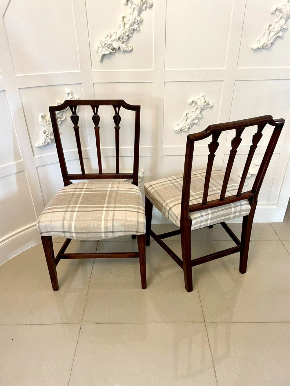 A set of eight George III mahogany dining chairs featuring carved vertical back splats and beige plaid upholstered drop-in seats, including six side chairs and two armchairs. View IX