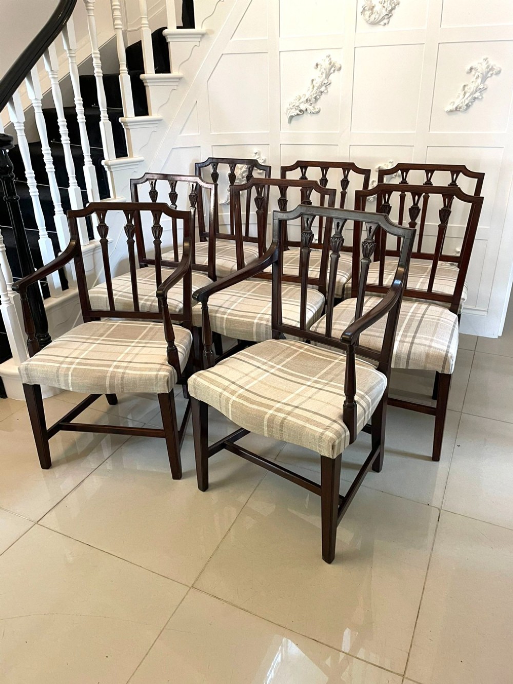 A set of eight George III mahogany dining chairs featuring carved vertical back splats and beige plaid upholstered drop-in seats, including six side chairs and two armchairs. View XI