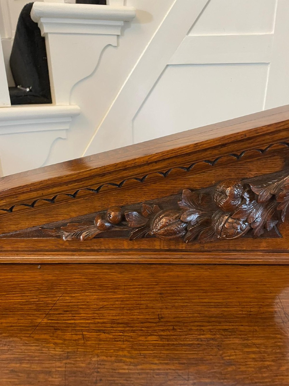 A three-tiered dark oak antique dumbwaiter featuring carved column supports, a carved gallery cresting, and bun feet. View III