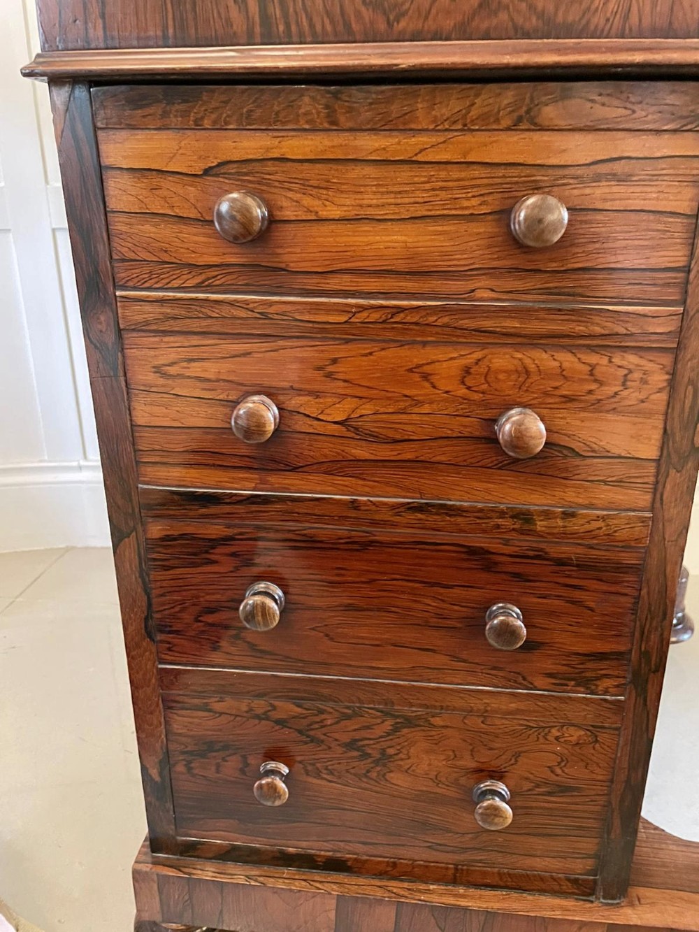 A Victorian rosewood Davenport desk featuring a sloped dark green leather writing surface, decorative brass gallery rail, carved cabriole front supports, and side drawers. View II