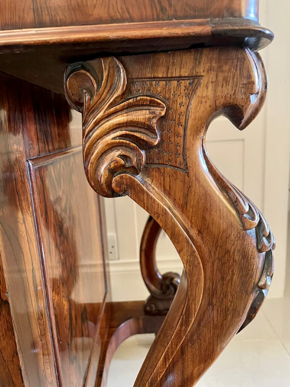 A Victorian rosewood Davenport desk featuring a sloped dark green leather writing surface, decorative brass gallery rail, carved cabriole front supports, and side drawers. View III