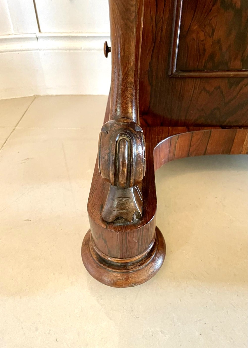 A Victorian rosewood Davenport desk featuring a sloped dark green leather writing surface, decorative brass gallery rail, carved cabriole front supports, and side drawers. View V