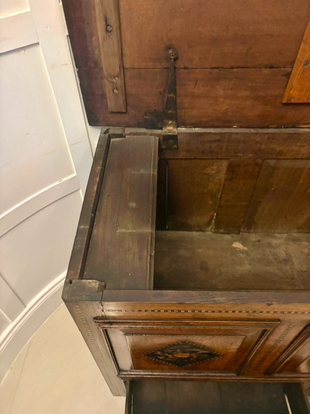 A seventeenth-century oak mule chest with three rectangular panelled sections containing central diamond floral marquetry inlays positioned above two base drawers. View II