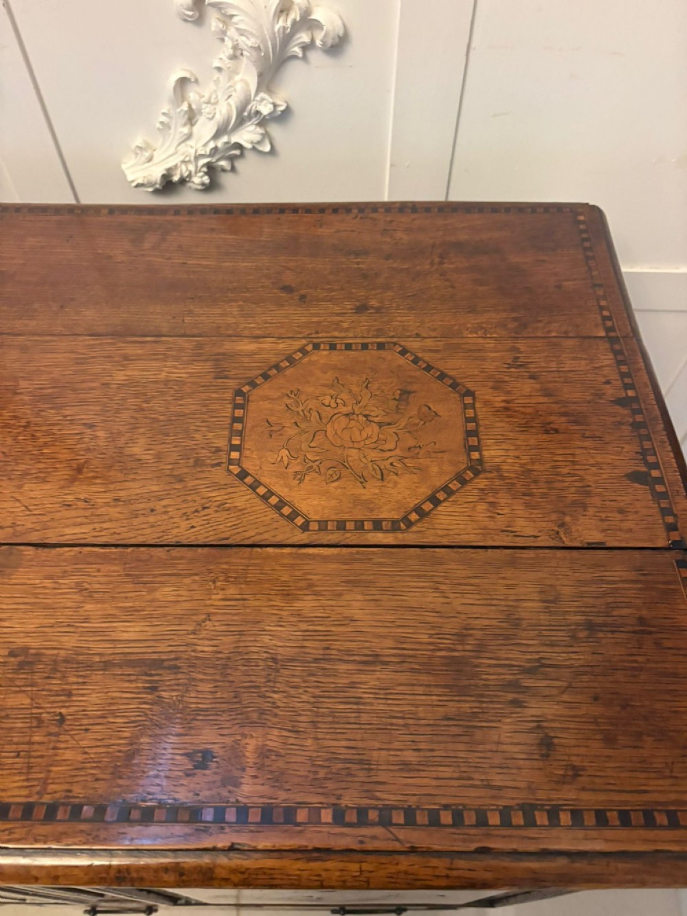 A seventeenth-century oak mule chest with three rectangular panelled sections containing central diamond floral marquetry inlays positioned above two base drawers. View VIII
