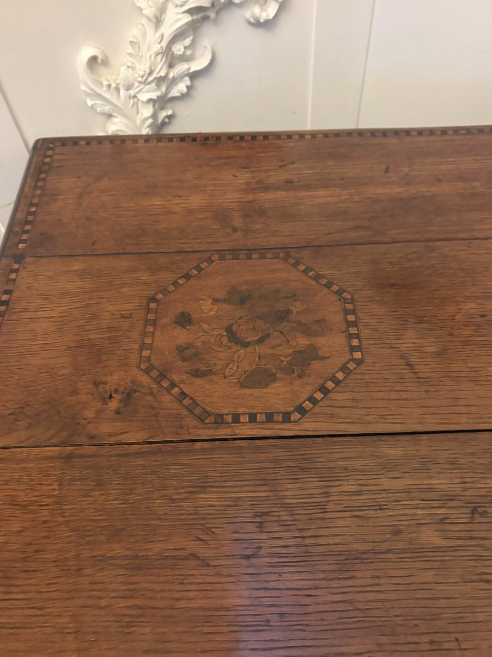 A seventeenth-century oak mule chest with three rectangular panelled sections containing central diamond floral marquetry inlays positioned above two base drawers. View XII