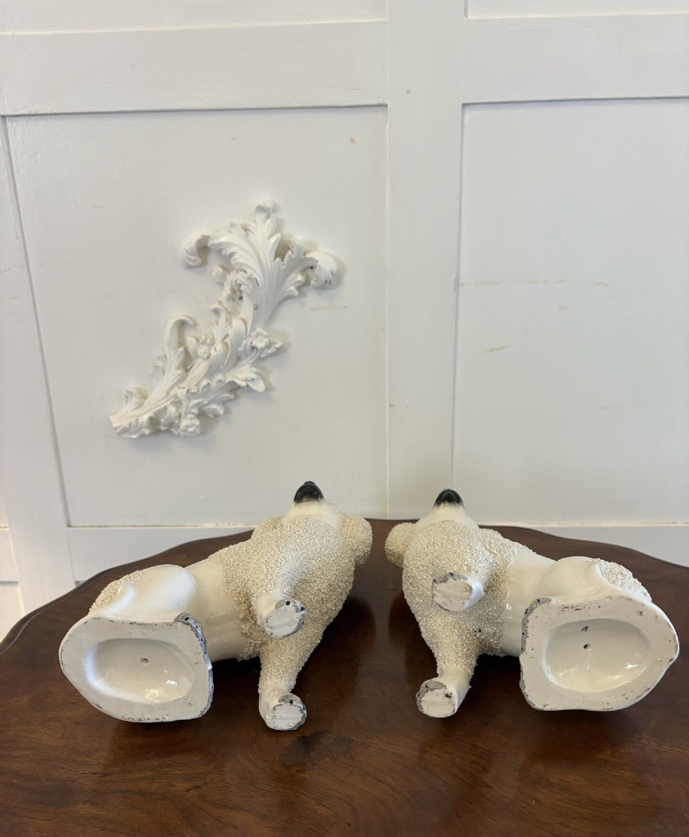 A matching pair of Victorian cream earthenware Staffordshire poodle figurines sitting upright with hand-applied textured fur and gilded collar details. View XI