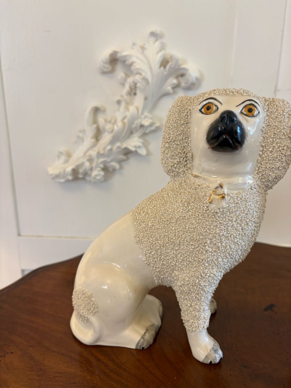 A matching pair of Victorian cream earthenware Staffordshire poodle figurines sitting upright with hand-applied textured fur and gilded collar details. View XII
