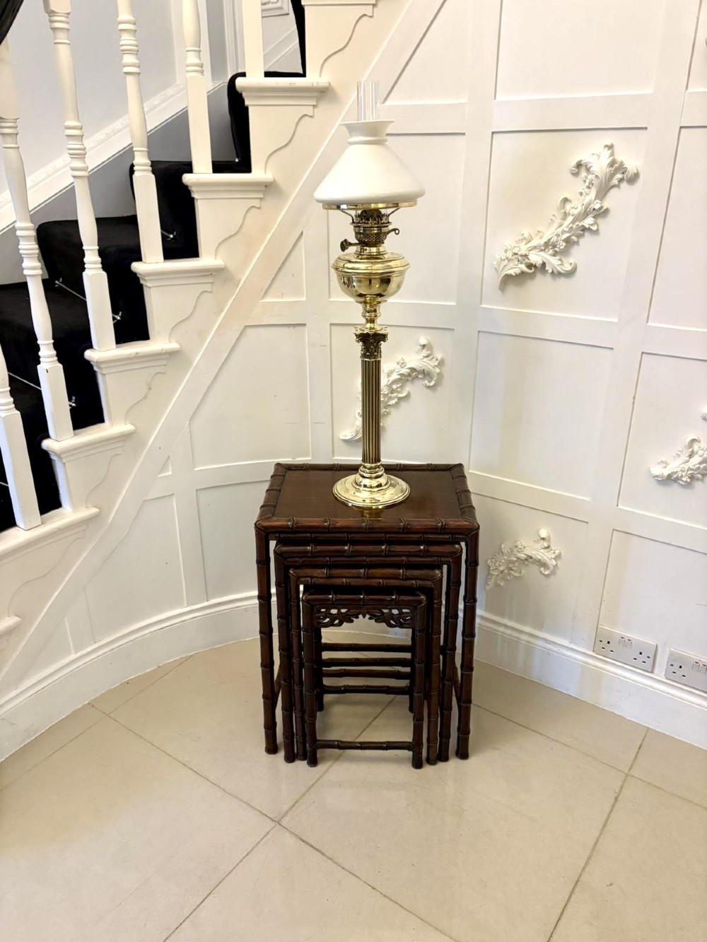 A set of four dark brown carved hardwood nesting tables featuring faux bamboo turnings and openwork carved aprons. View V