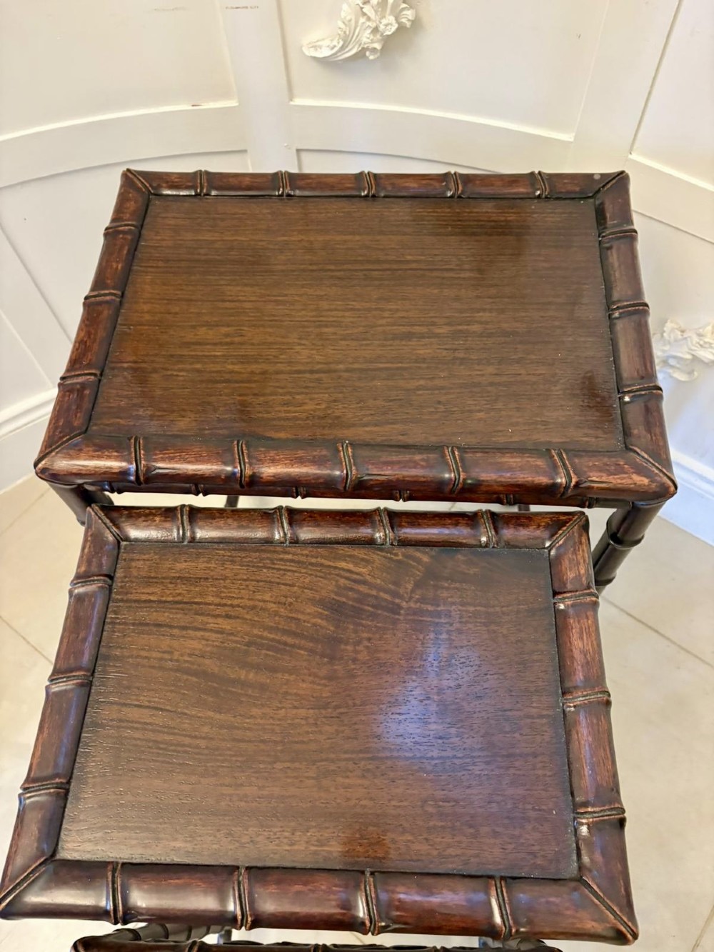 A set of four dark brown carved hardwood nesting tables featuring faux bamboo turnings and openwork carved aprons. View VII