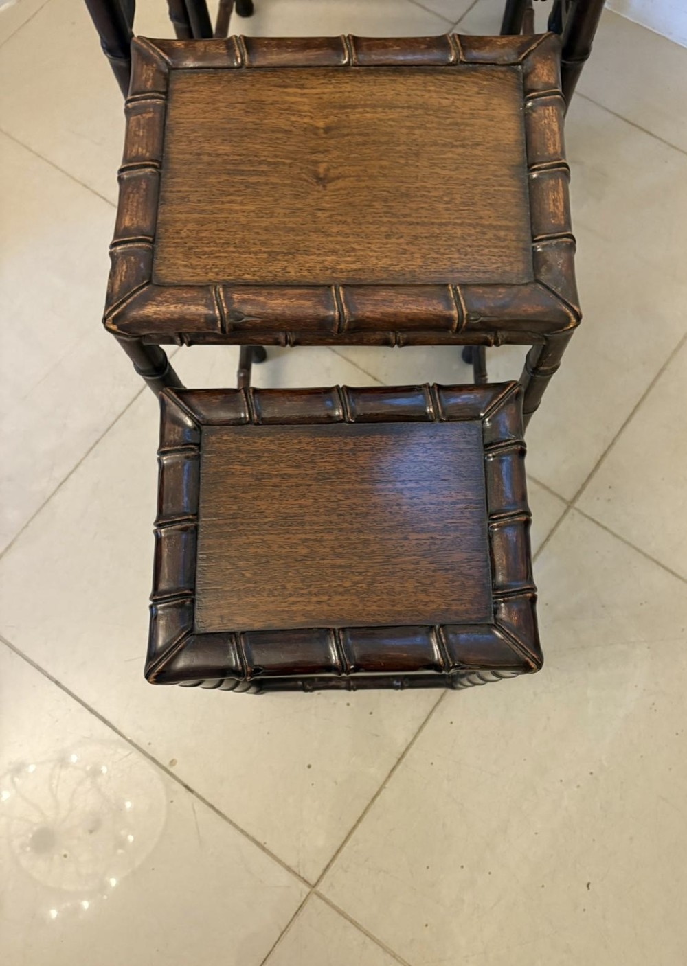 A set of four dark brown carved hardwood nesting tables featuring faux bamboo turnings and openwork carved aprons. View VIII