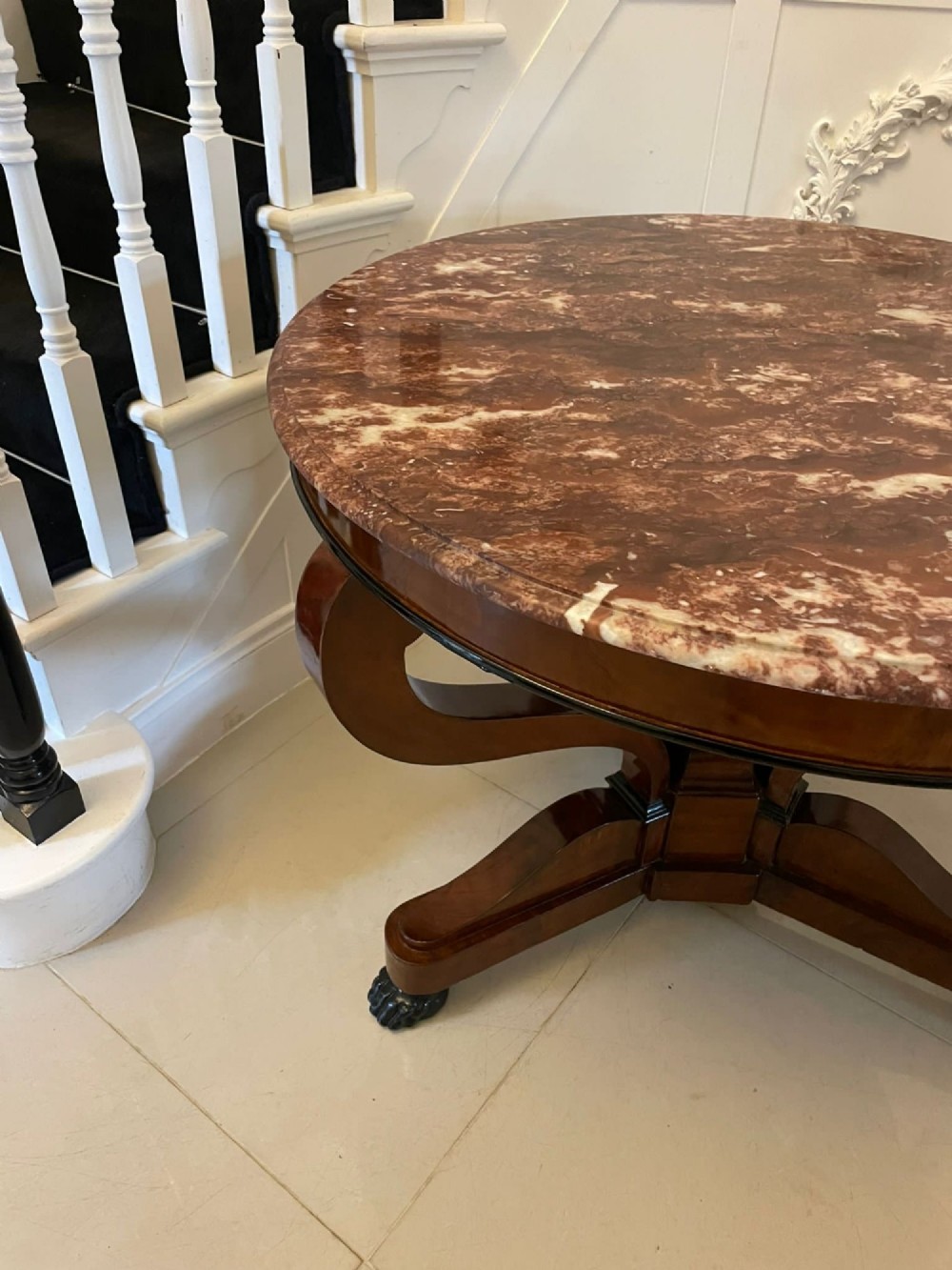 A circular antique French centre table featuring a polished red-and-white variegated marble top on a mahogany apron with curved legs and carved paw feet. View III