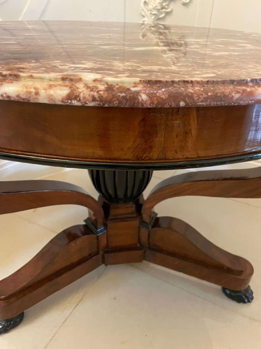 A circular antique French centre table featuring a polished red-and-white variegated marble top on a mahogany apron with curved legs and carved paw feet. View VII