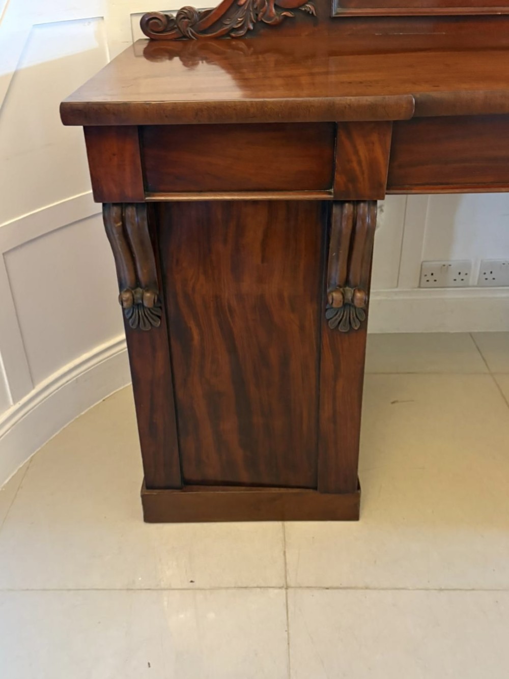 A Victorian mahogany pedestal sideboard featuring a raised backboard with carved scrollwork and two flanking pedestal cupboards. View XIII