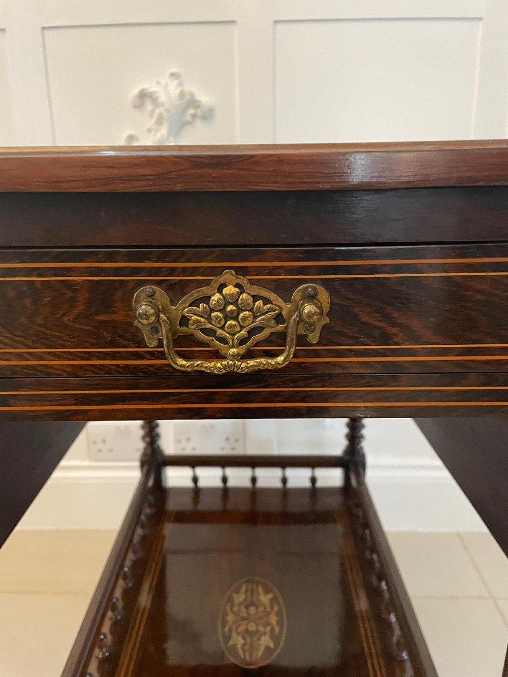 A Victorian rosewood drop-leaf centre table featuring floral marquetry inlay, turned legs on brass castors, and a lower tiered shelf with a spindle gallery. View VI