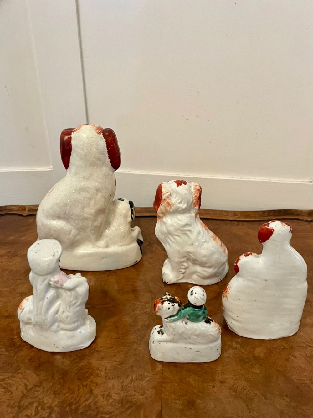 A collection of six antique Victorian earthenware Staffordshire dog figures with hand-painted rust red, black, and polychrome detailing. View III