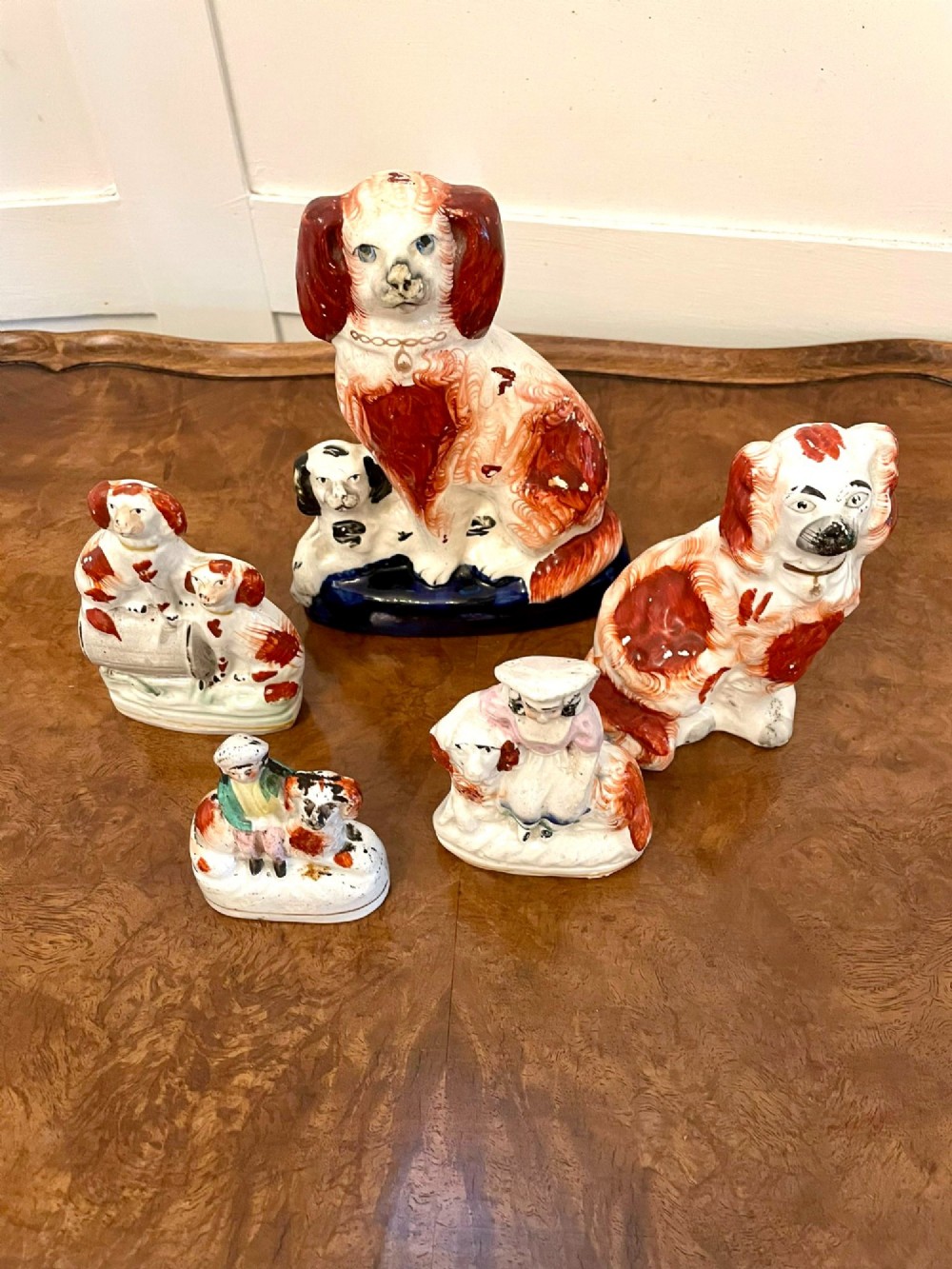 A collection of six antique Victorian earthenware Staffordshire dog figures with hand-painted rust red, black, and polychrome detailing. View IV