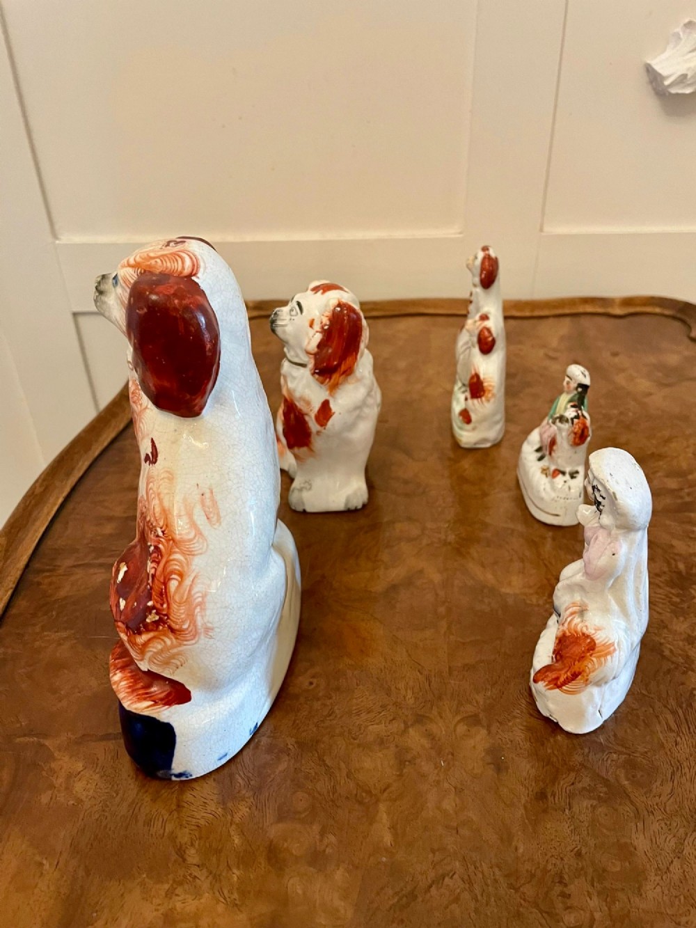 A collection of six antique Victorian earthenware Staffordshire dog figures with hand-painted rust red, black, and polychrome detailing. View VIII