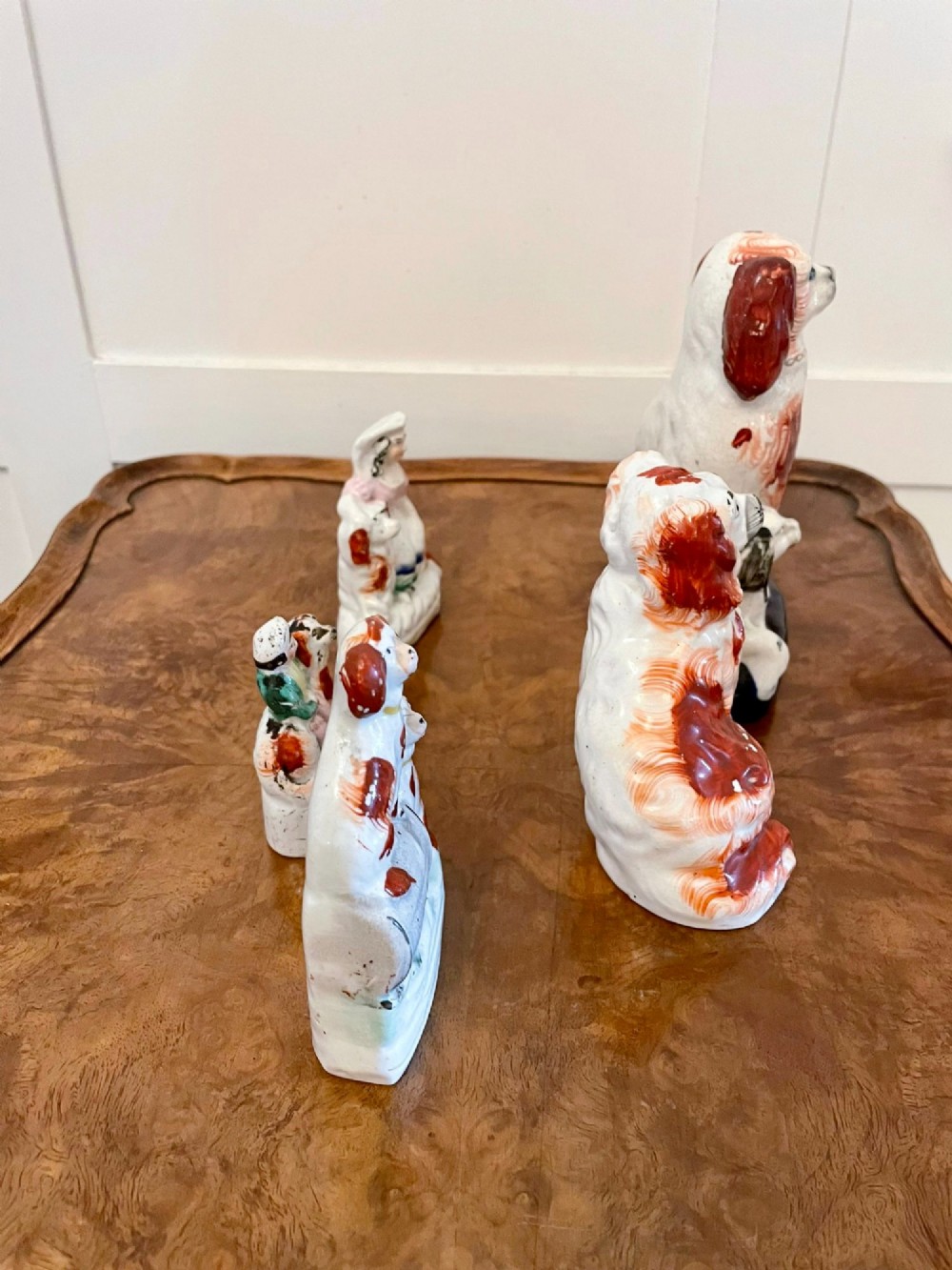 A collection of six antique Victorian earthenware Staffordshire dog figures with hand-painted rust red, black, and polychrome detailing. View X