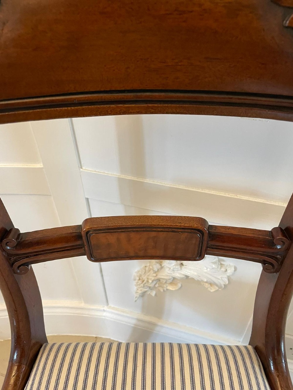 A set of four antique mahogany dining chairs featuring carved scroll top rails, turned front legs, and blue and white striped upholstered seats. View II
