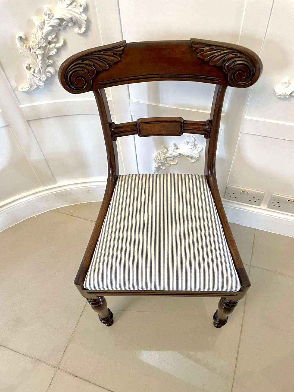A set of four antique mahogany dining chairs featuring carved scroll top rails, turned front legs, and blue and white striped upholstered seats. View III