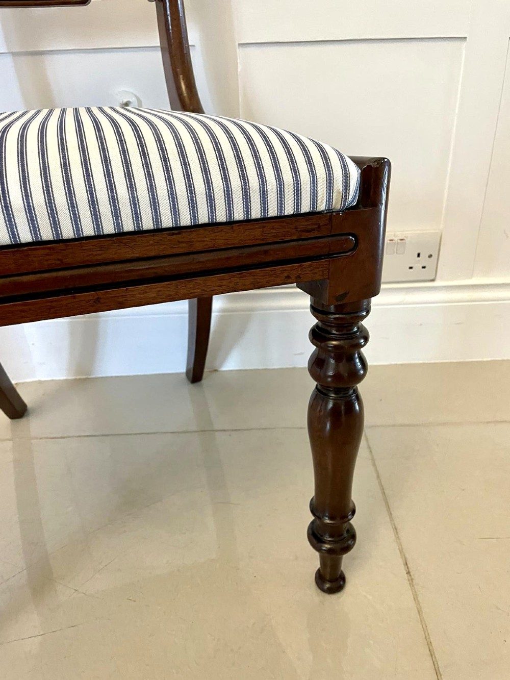 A set of four antique mahogany dining chairs featuring carved scroll top rails, turned front legs, and blue and white striped upholstered seats. View IV
