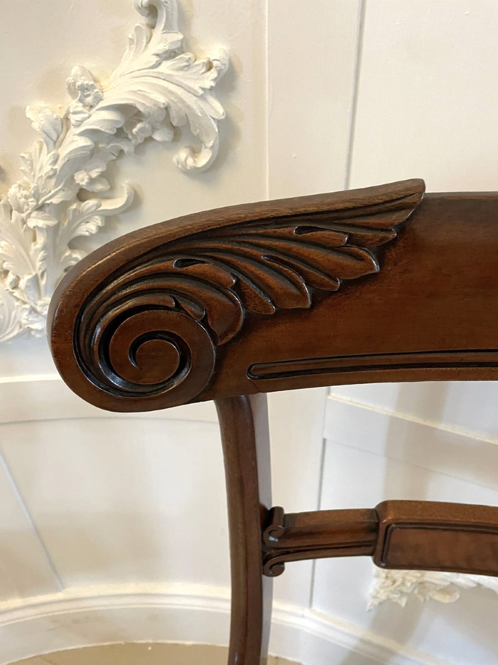A set of four antique mahogany dining chairs featuring carved scroll top rails, turned front legs, and blue and white striped upholstered seats. View VI