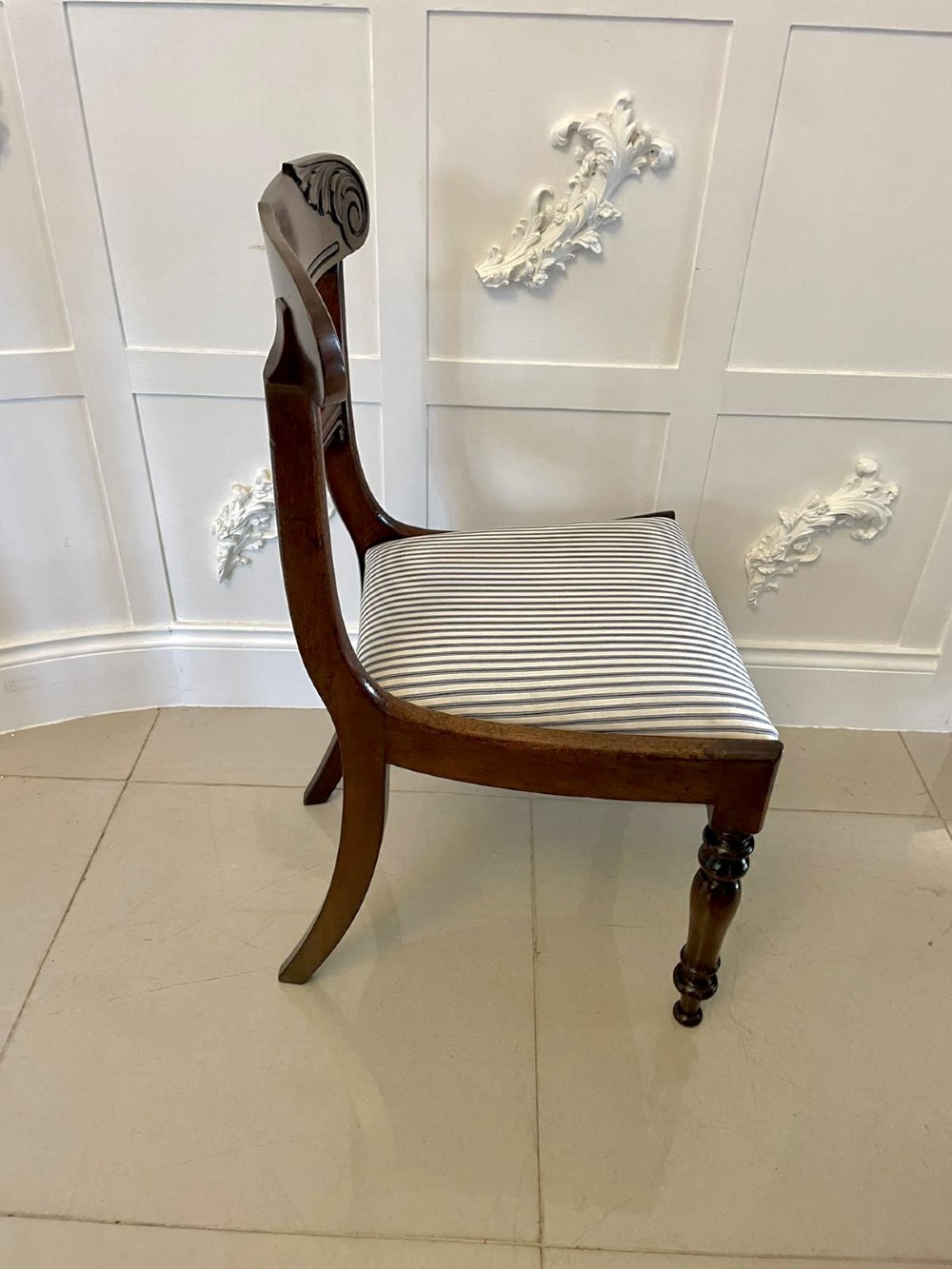 A set of four antique mahogany dining chairs featuring carved scroll top rails, turned front legs, and blue and white striped upholstered seats. View VIII
