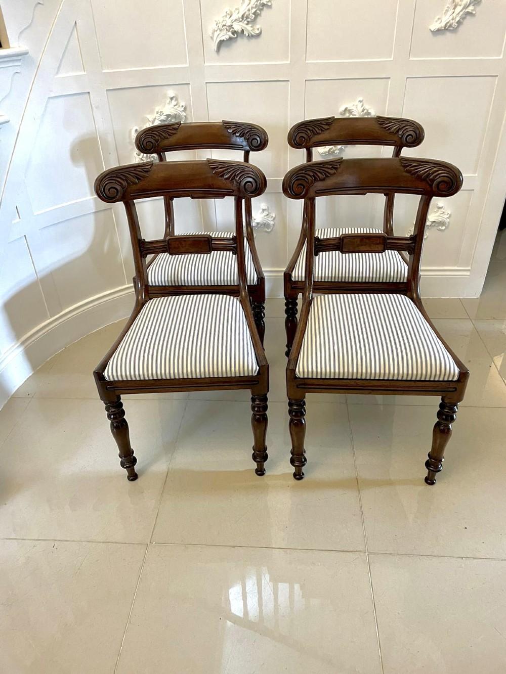 A set of four antique mahogany dining chairs featuring carved scroll top rails, turned front legs, and blue and white striped upholstered seats. View XV