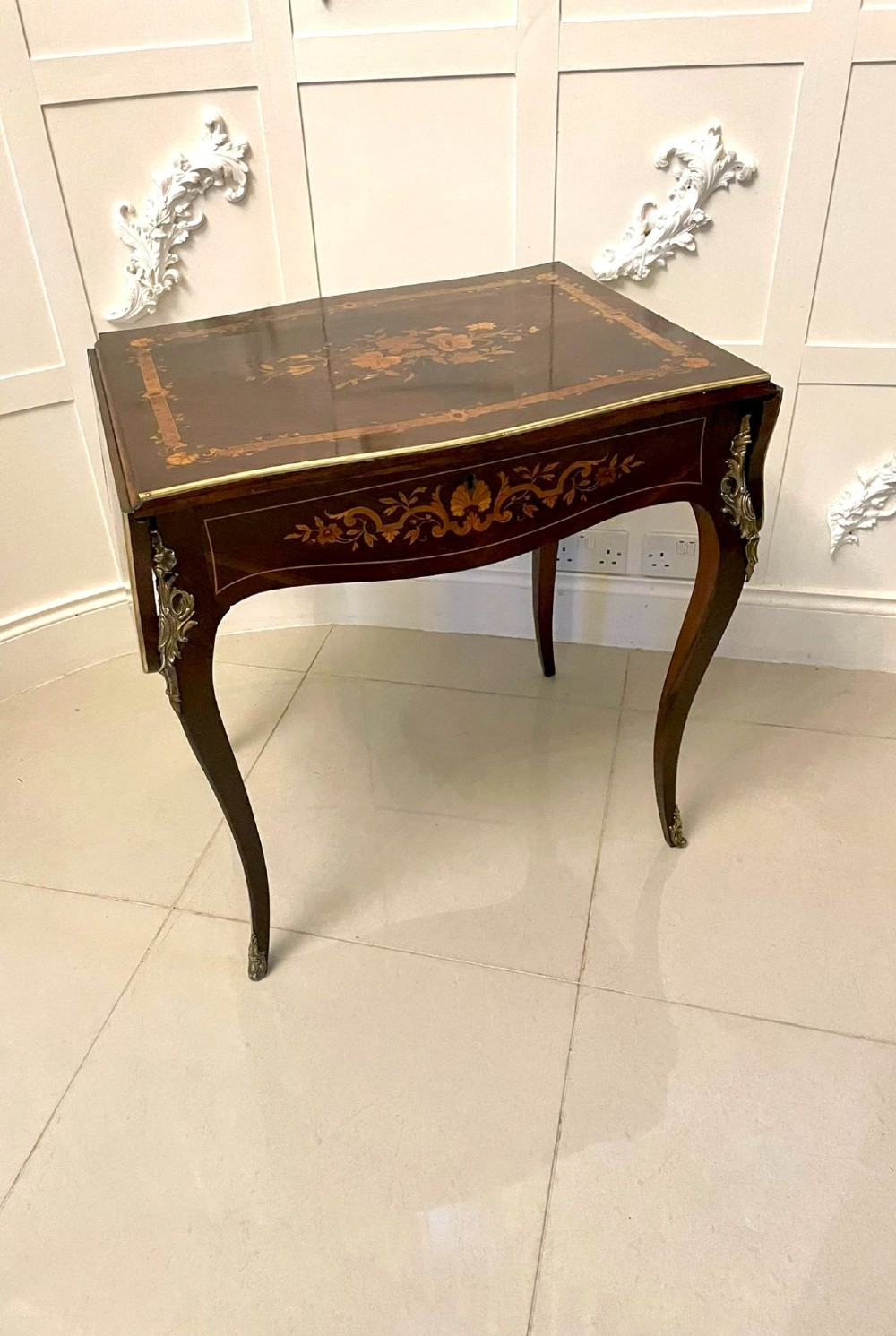 A French Louis XV style rosewood centre table featuring floral marquetry inlay, sweeping cabriole legs, and ornate gilt bronze mounts.