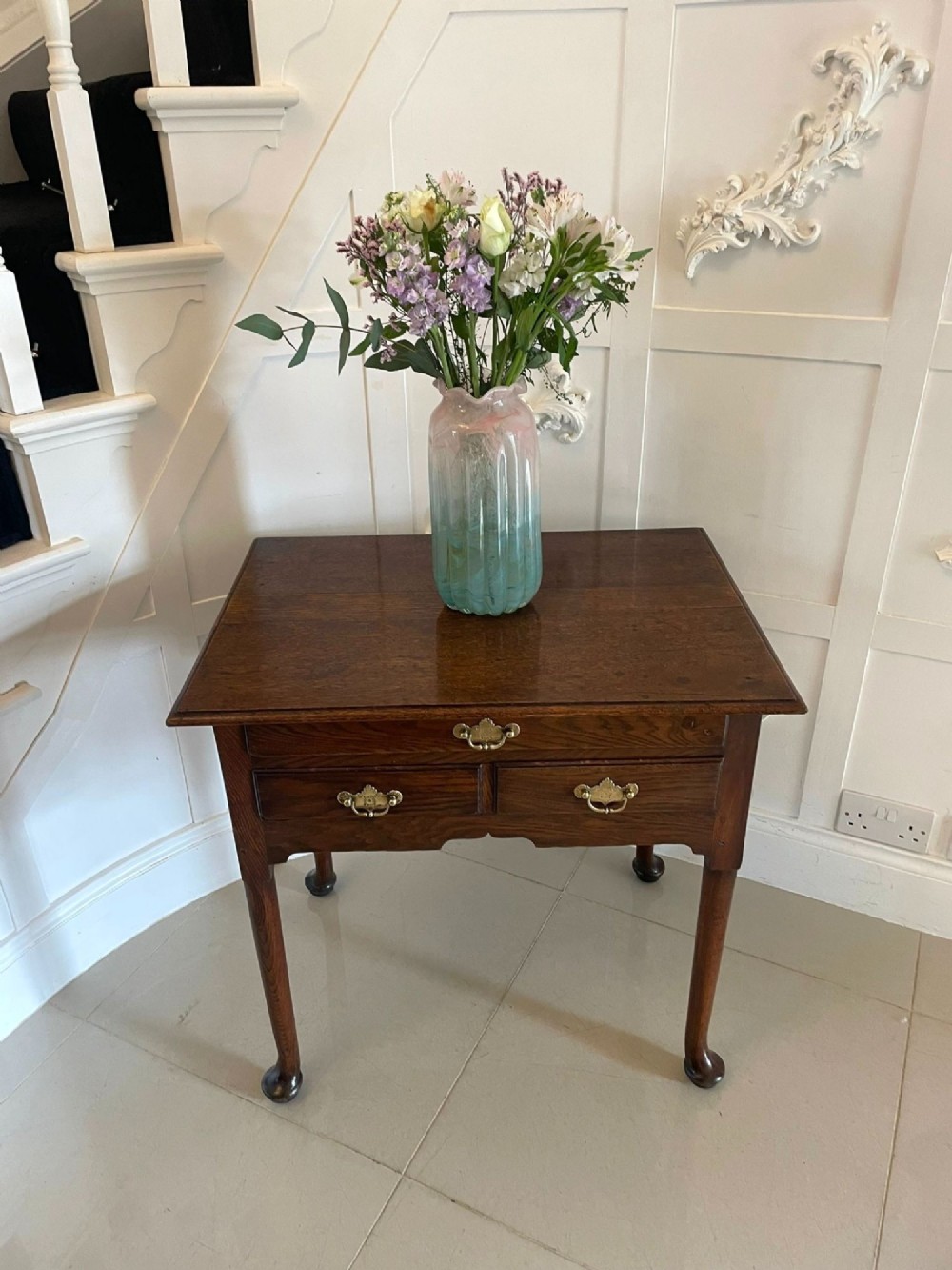 A George III oak lowboy table with three drawers, brass handles, a shaped apron, and cabriole legs with pad feet. View II