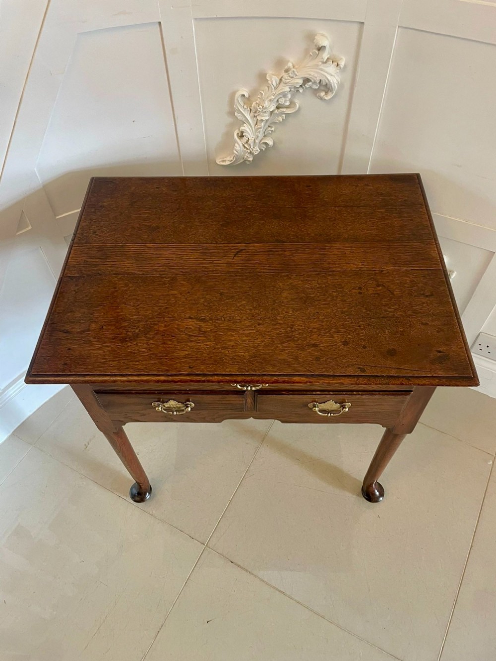 A George III oak lowboy table with three drawers, brass handles, a shaped apron, and cabriole legs with pad feet. View IV