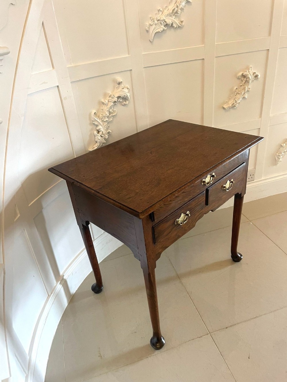 A George III oak lowboy table with three drawers, brass handles, a shaped apron, and cabriole legs with pad feet. View V