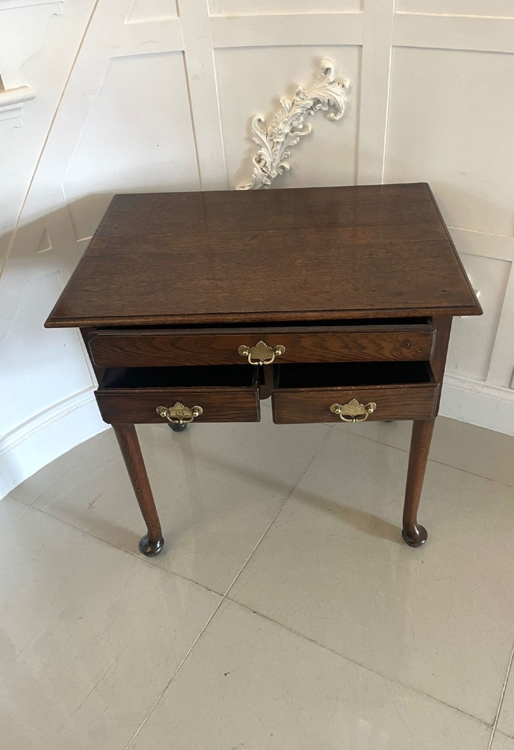A George III oak lowboy table with three drawers, brass handles, a shaped apron, and cabriole legs with pad feet. View VI