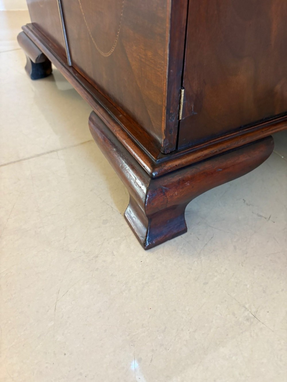 A tall Victorian mahogany glazed bookcase featuring a swan-neck pediment, geometric astragal glazing, an inlaid drawer, and a lower two-door cupboard. View IX