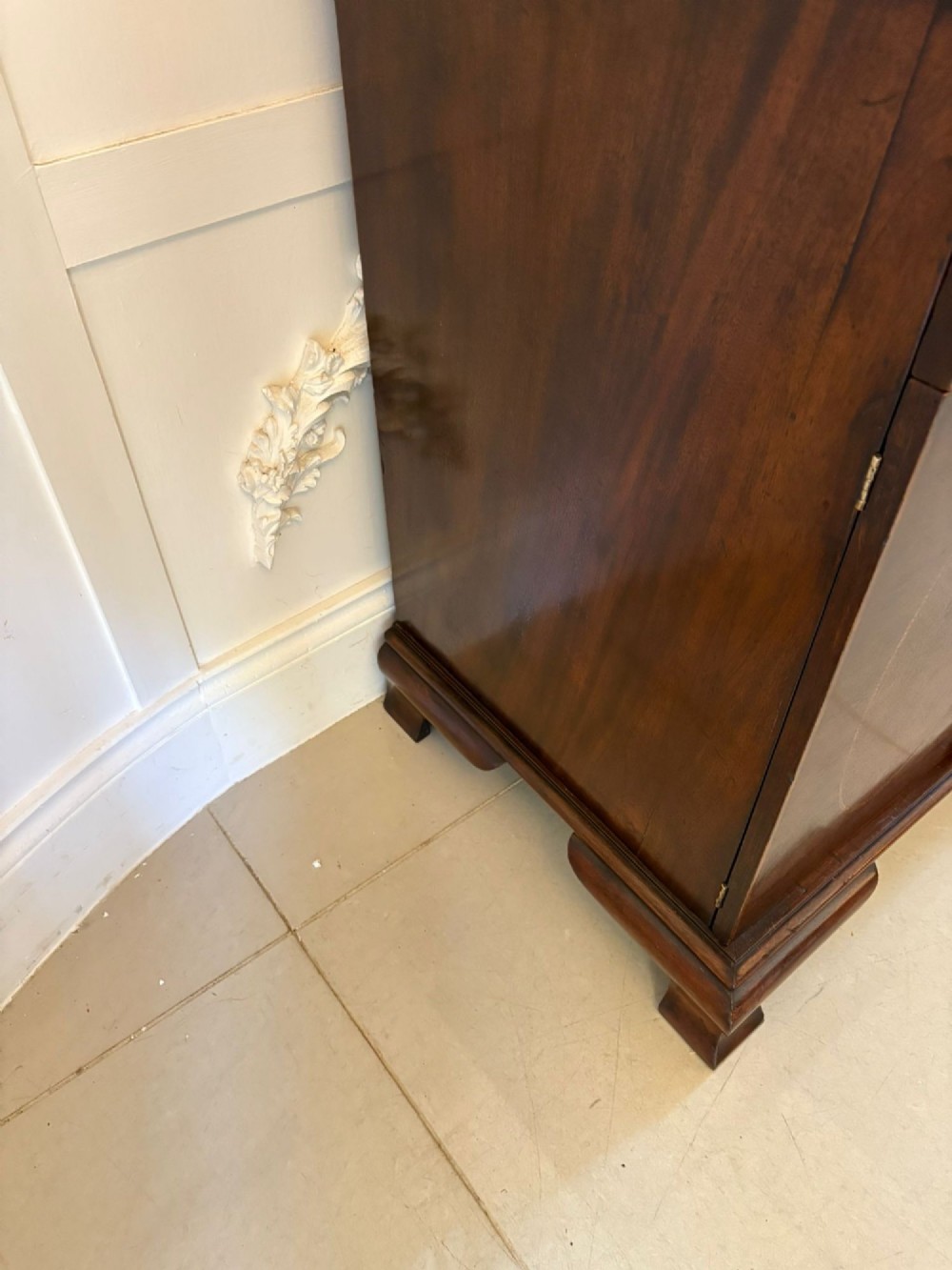 A tall Victorian mahogany glazed bookcase featuring a swan-neck pediment, geometric astragal glazing, an inlaid drawer, and a lower two-door cupboard. View X