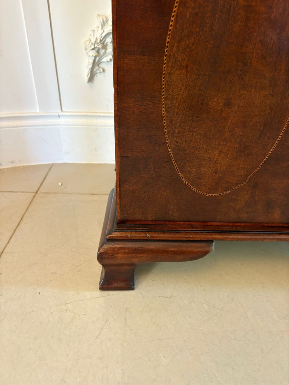 A tall Victorian mahogany glazed bookcase featuring a swan-neck pediment, geometric astragal glazing, an inlaid drawer, and a lower two-door cupboard. View XIII