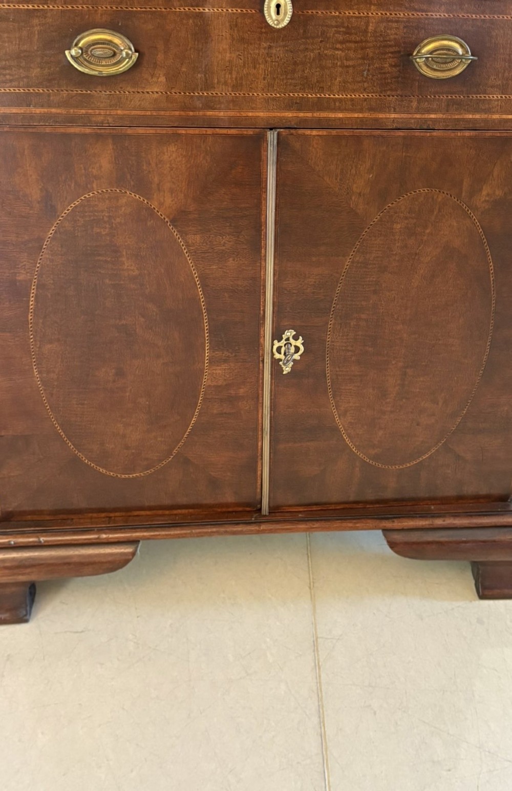 A tall Victorian mahogany glazed bookcase featuring a swan-neck pediment, geometric astragal glazing, an inlaid drawer, and a lower two-door cupboard. View XIV