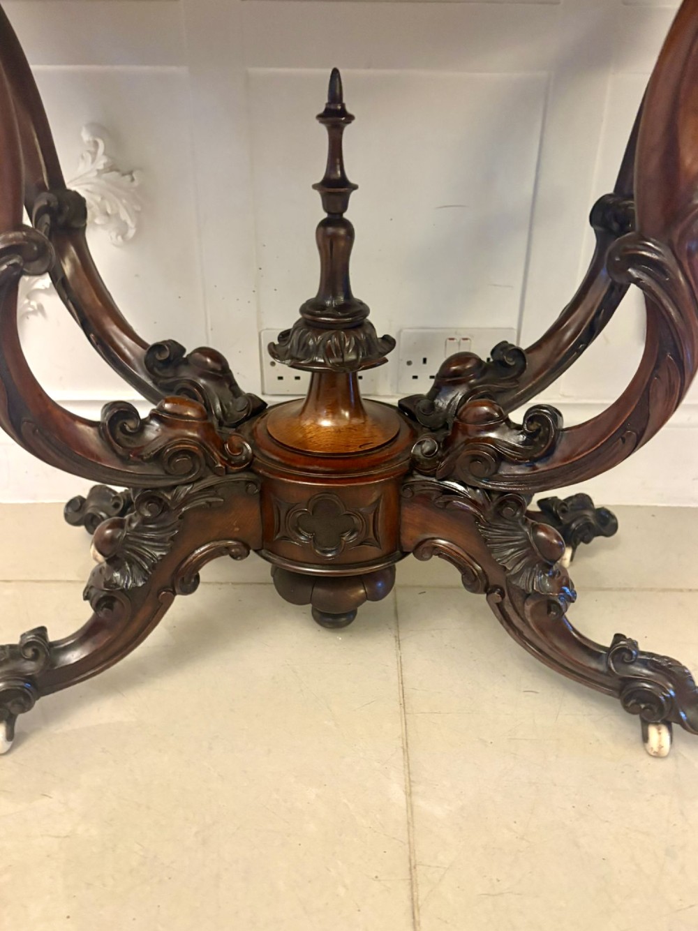 A Victorian burr walnut card table featuring a serpentine-shaped fold-over top set upon a carved pedestal base with four scroll feet on castors. View VIII