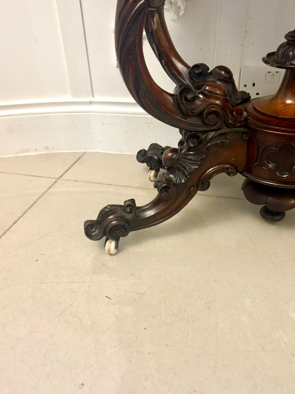 A Victorian burr walnut card table featuring a serpentine-shaped fold-over top set upon a carved pedestal base with four scroll feet on castors. View XI