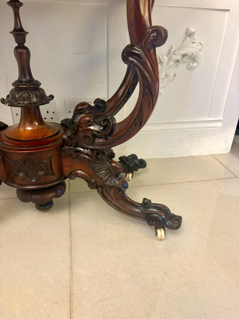 A Victorian burr walnut card table featuring a serpentine-shaped fold-over top set upon a carved pedestal base with four scroll feet on castors. View XIV