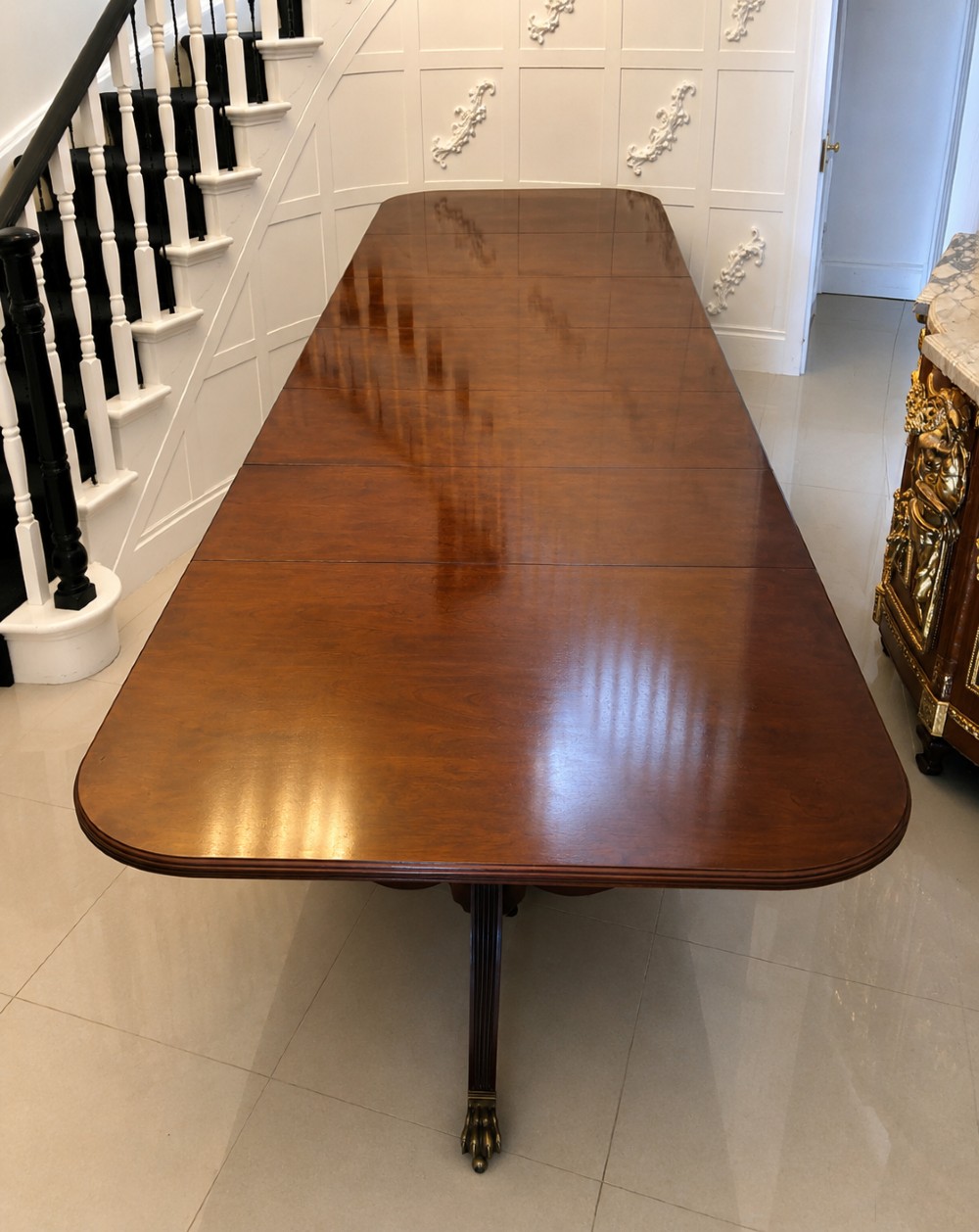 An exceptionally long mahogany banquet dining table supported on four turned pedestals with splayed legs and brass castors. View VIII